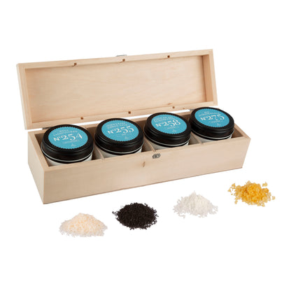 Salz Geschenkbox aus Holz mit vier sichtbaren Gourmetsalzen, darunter Fleur de Sel und schwarzes Salz.