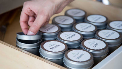 Eine Hand öffnet eine Gewürzdose mit Aromadeckel, PAPRIKA-Aufkleber im Schubfach sichtbar.