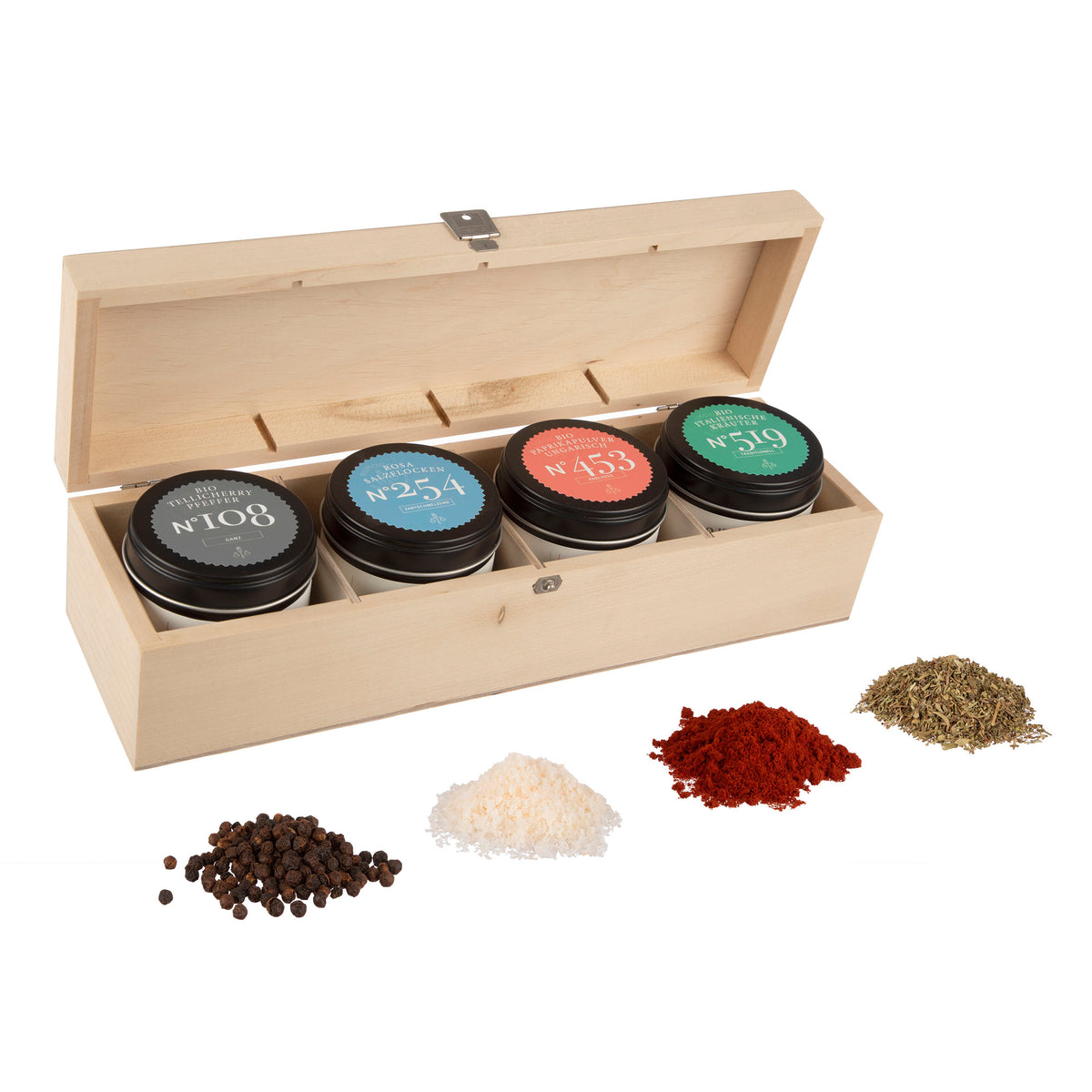 Holzbox mit vier Gewürzdosen, rosa Salzflocken, Tellicherry Pfeffer und Kräutern.