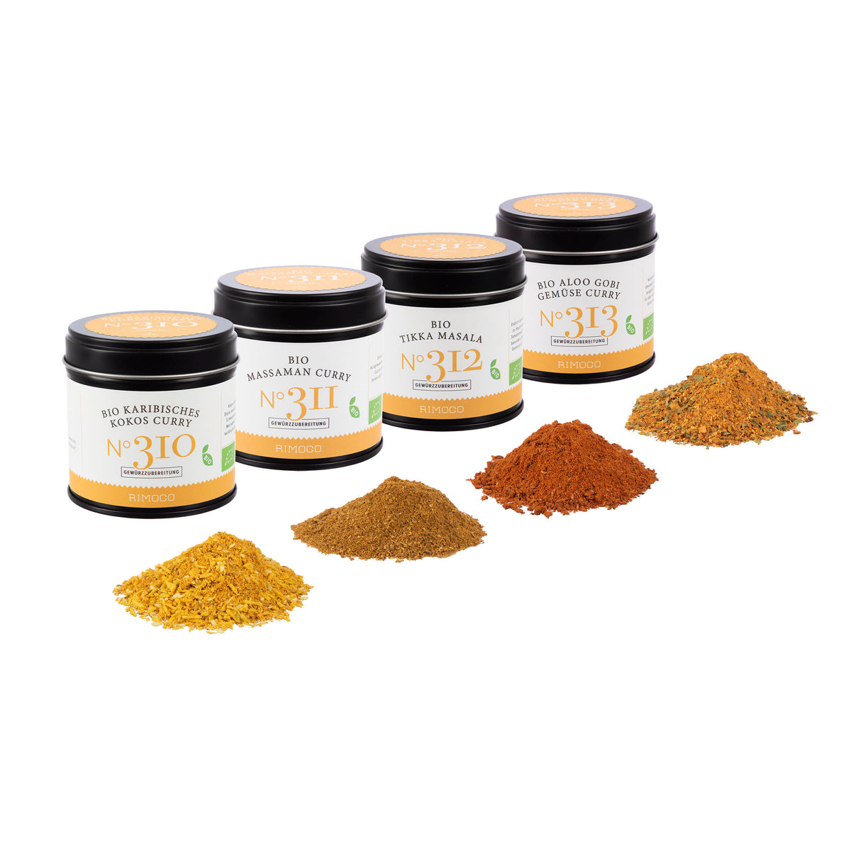 Vier Gläser Bio Curry Gewürz-Set N°1, davor bunter Haufen gemahlener Currypulver.