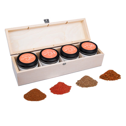 Offene Holzbox mit Grillgewürzen Geschenkbox N°2 Gewürzgläsern und gemahlenen Gewürzen davor.
