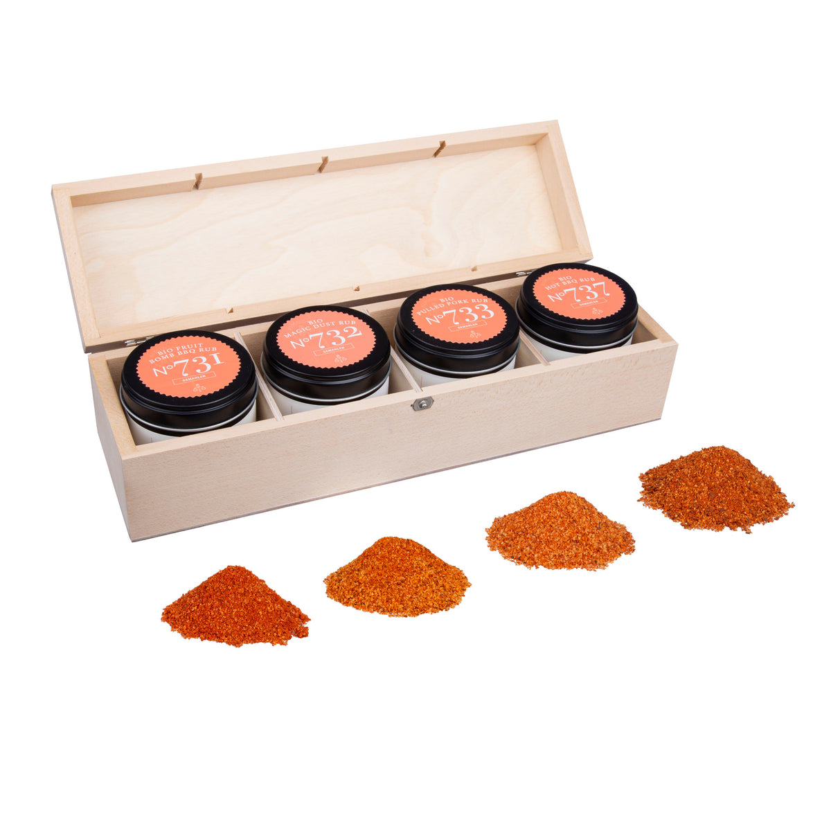 BBQ Rubs Geschenkbox mit vier Gewürzdosen und bunten, gemahlenen Gewürzhäufchen davor.