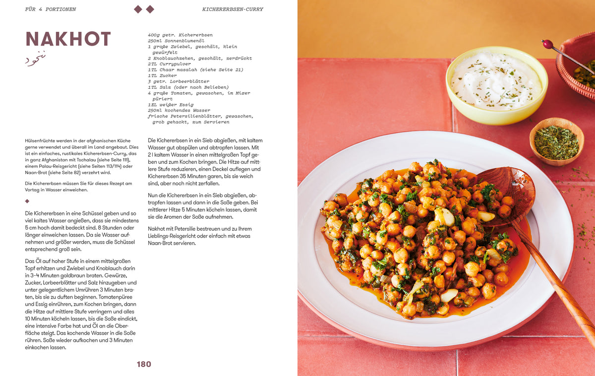 Ein Teller Kichererbsencurry mit Kräutern, Geschenkset Parwana und Joghurtsoße auf rotem Tisch.