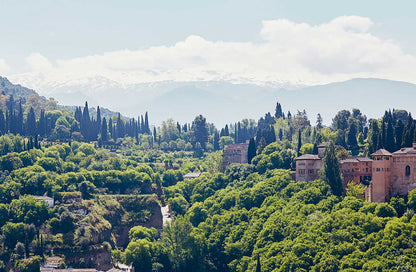 Grüne Hügel, historische Gebäude und ferne Berge, wie in einem Geschenkset Andalusiens zu sehen.