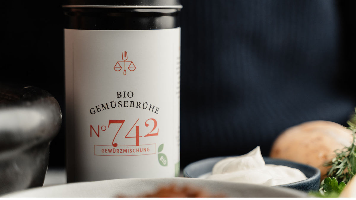 Bio-Gemüsebrühe Nr. 742, dazu frische Kräuter und eine Schüssel cremige Suppe.