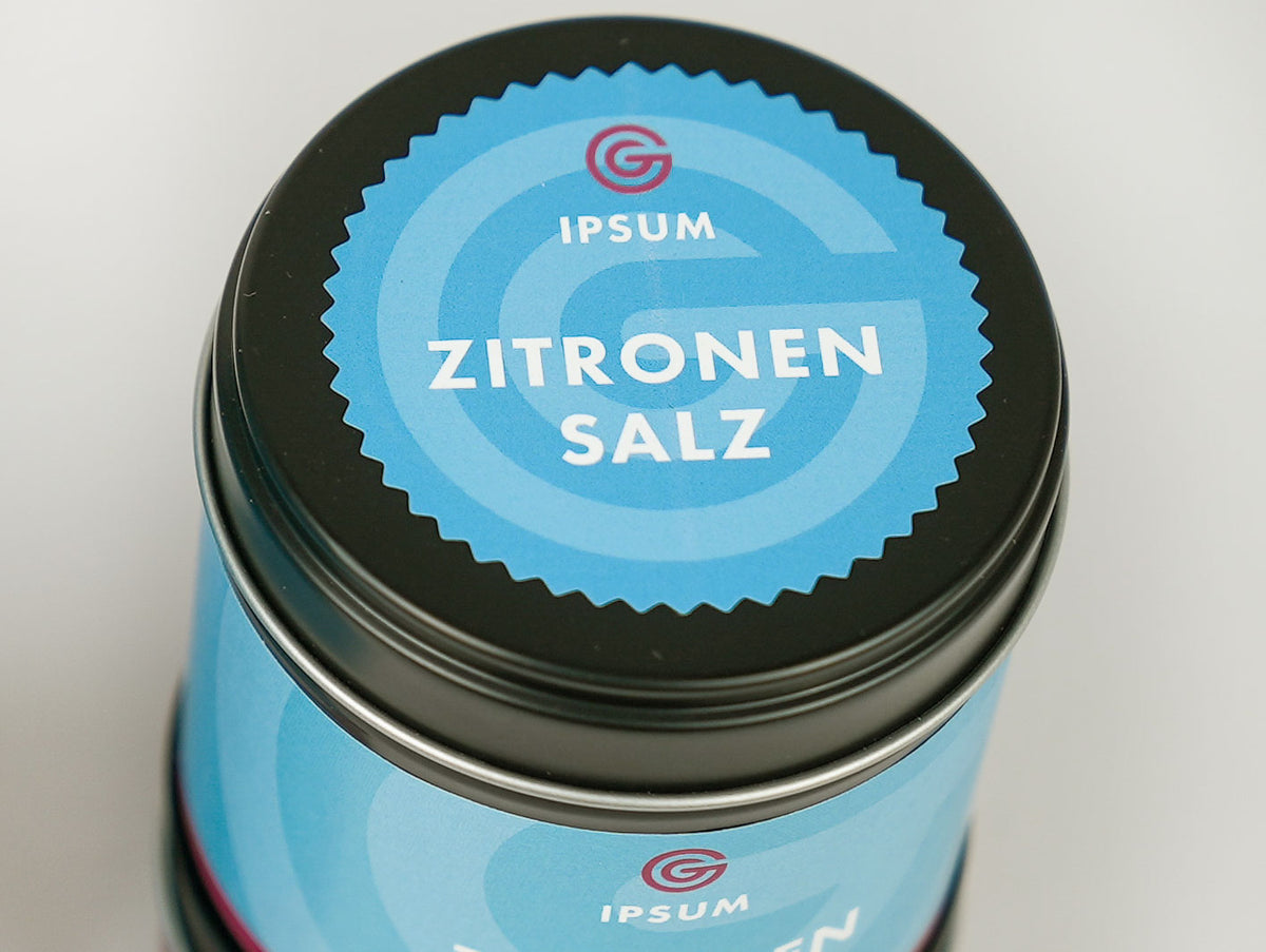 Blauer Metalldeckel mit weißer Aufschrift „IPSUM ZITRONEN SALZ“ in klaren Buchstaben.