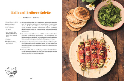 Vier Spieße mit Halloumi, Erdbeeren und Zucchini auf einem Teller.