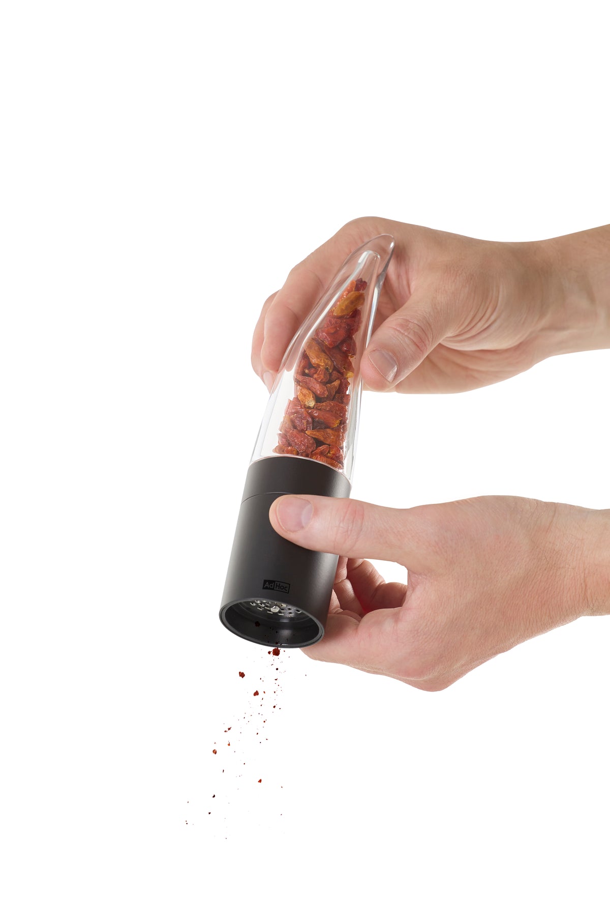 Chilischneider Pepe schwarz mahlt getrocknete Chilis, unten sind frische Chiliflocken zu sehen.