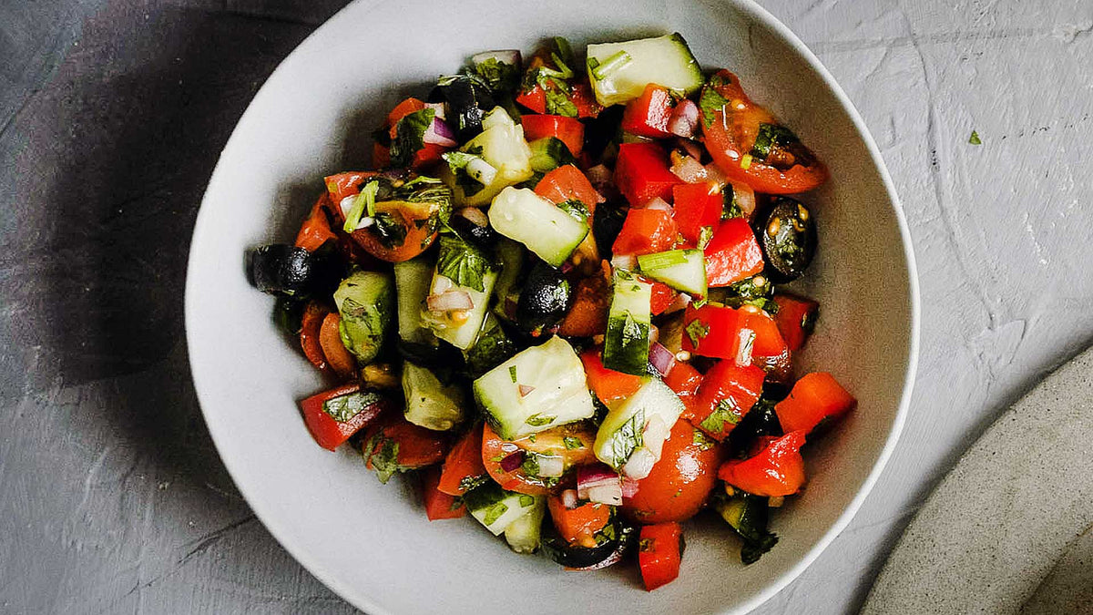 Salat mit Gurken, Tomaten, Paprika, Oliven, Zwiebeln, Kräutern und gemahlenem grünen Jalapeño-Chili.