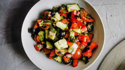 Salat mit Gurken, Tomaten, Paprika, Oliven, Zwiebeln, Kräutern und gemahlenem grünen Jalapeño-Chili.