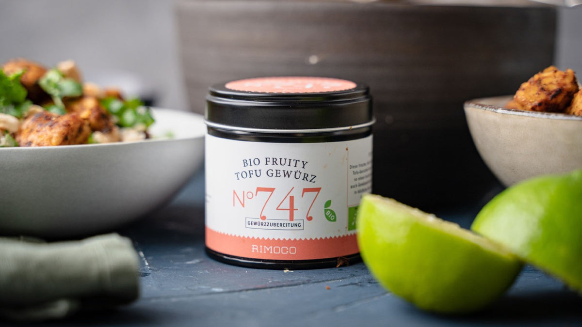 Rimoco Bio Fruity Tofu Nr. 747, dazu Limettenstücke und bunte Schüsseln mit Essen.