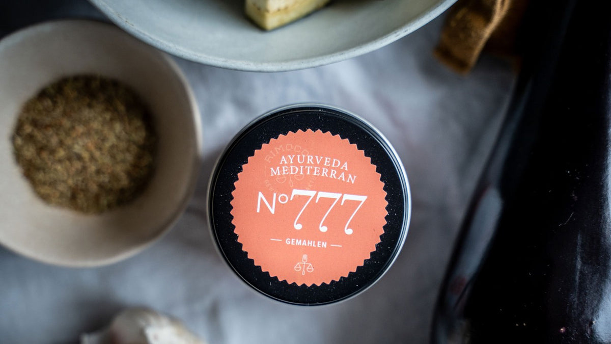 Servieren Sie „Ayurveda Mediterran Nr. 777“ auf einem Tisch mit mediterranen Speisen und Zutaten.