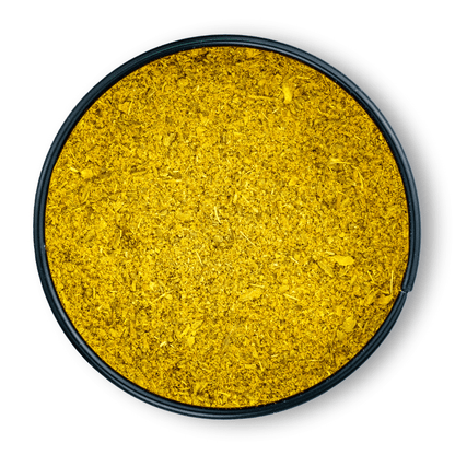 Fein gemahlenes gelbes Bio Ayurveda Dosha Pitta in einem runden schwarzen Behälter, von oben gesehen.