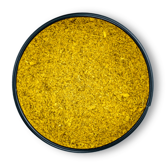 Fein gemahlenes gelbes Bio Ayurveda Dosha Pitta in einem runden schwarzen Behälter, von oben gesehen.