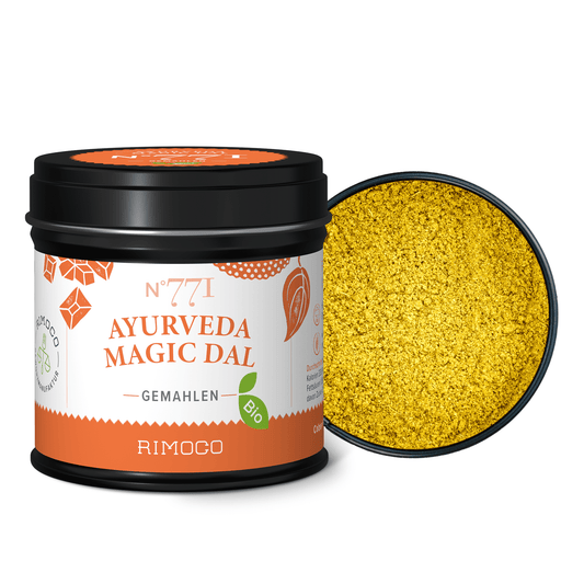 Bio Ayurveda Magic Dal Dose, schwarz, offen, daneben gelbes gemahlenes Gewürz.