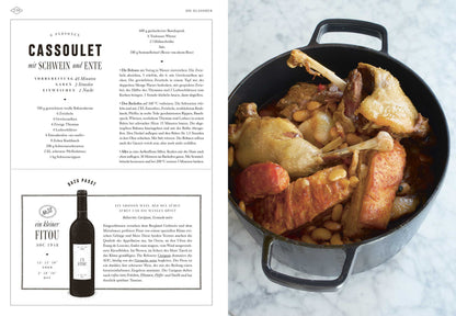Ein Topf Cassoulet mit Wurst, Ente und Bohnen steht neben Bistro, Bistro! auf der Arbeitsplatte.