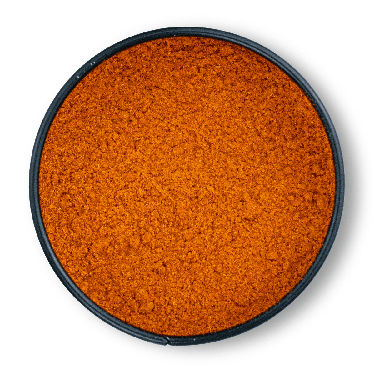Runde schwarze Schale mit leuchtend orange-rotem, gemahlenem Bio-Cayennepfeffer von oben fotografiert.