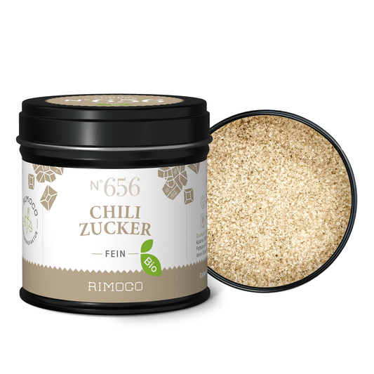 Feiner, hellbrauner Zucker ist in einer Dose mit Aufschrift Bio Chili Zucker zu sehen, Deckel abgenommen.