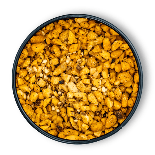 Runde Schale mit Bio Dukkah Gewürz Snackmischung auf weißem Hintergrund.