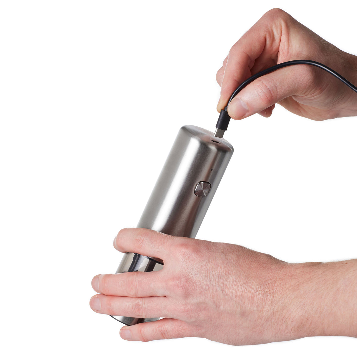 Zwei Hände halten eine elektrische Salz- und Pfeffermühle von Adhoc vor weißem Hintergrund.