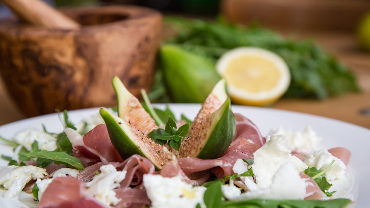 Salat mit Prosciutto, Mozzarella, Rucola und Feigen, verfeinert mit Bertoni Aceto Balsamico di Modena.