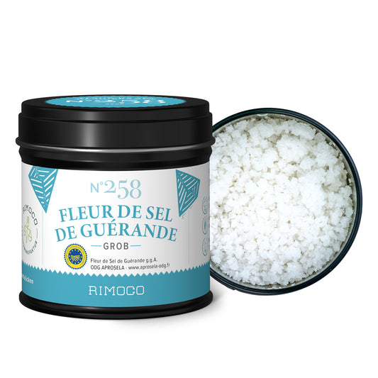 Schwarze, zylindrische Dose mit grobem, weißem Fleur de Sel aus Guérande.