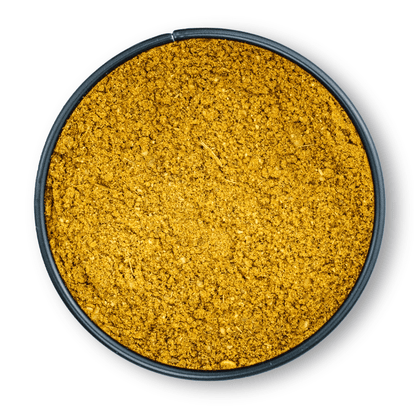Gelbes, gemahlenes Garam Masala in einem runden, schwarzen Behälter von oben gesehen.