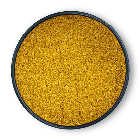Runde schwarze Schale mit gelbem, gemahlenem Curry-Pulver aus der Vogelperspektive auf Weiß.