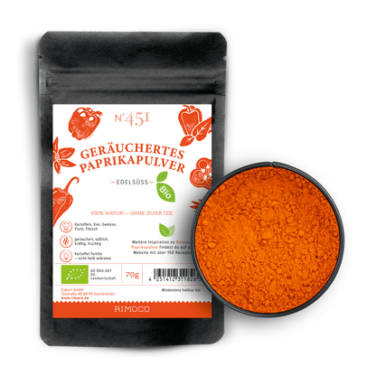Bio geräuchertes Paprikapulver edelsüß in schwarzem Beutel mit einer Schale orangen Pulvers daneben.