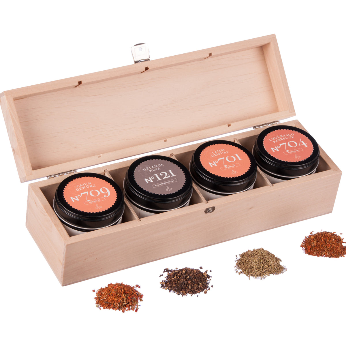 Grillgewürze Geschenkbox N°1 mit vier beschrifteten Dosen und losen Gewürzmischungen davor.