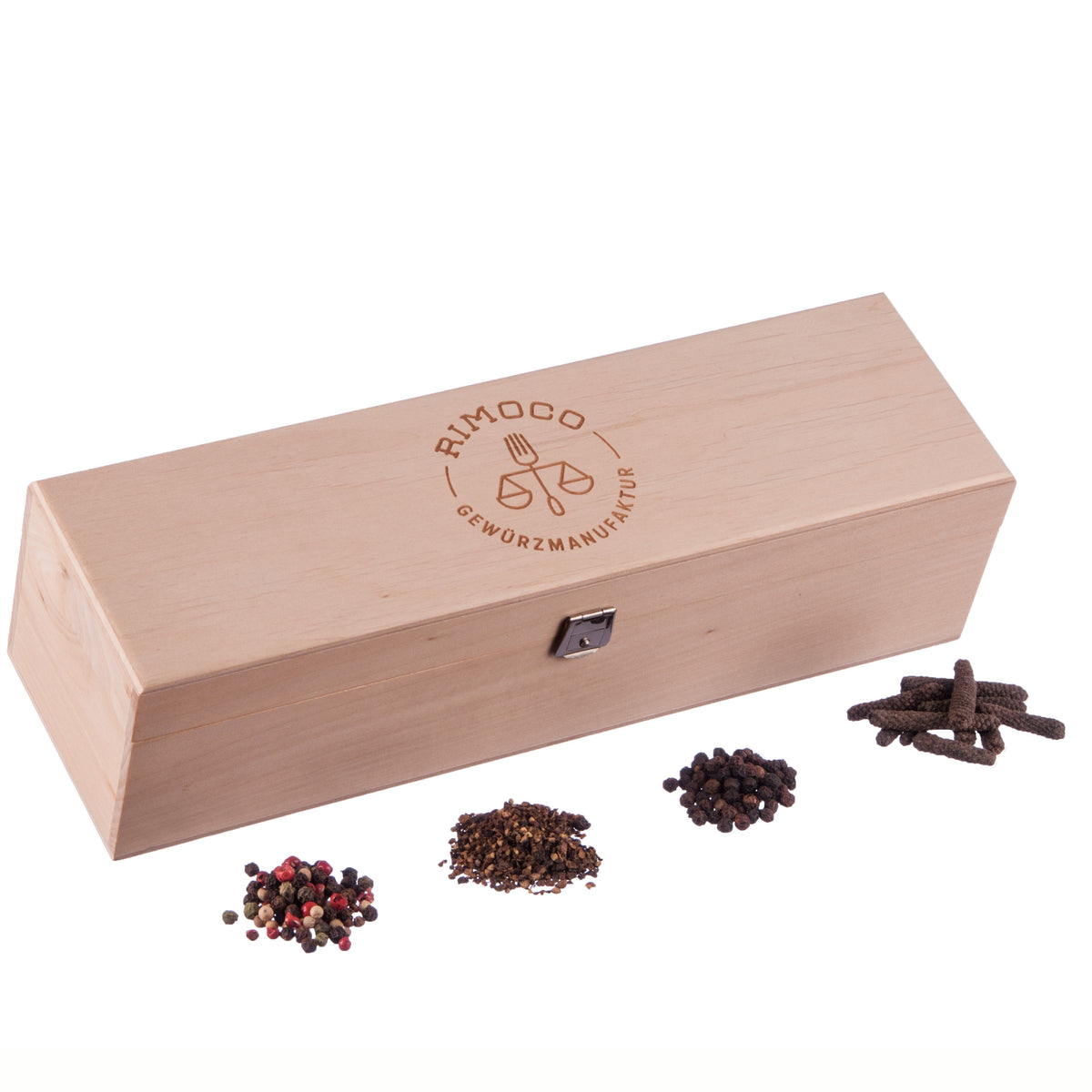 Holz-Gewürzbox mit Verschluss und Logo auf dem Deckel, davor vier Häufchen Tellicherry Pfeffer.