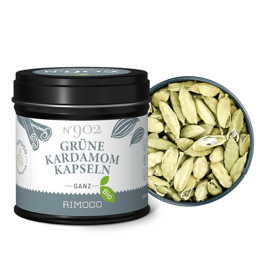 Offene Dose mit Aufschrift Bio Grüne Kardamomkapseln, daneben grüne Kardamomkapseln im Deckel.