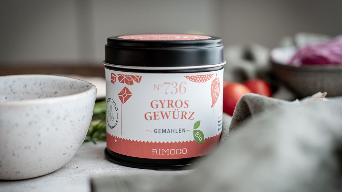 Rimoco Gyros-Gewürzdose auf einem Tisch mit frischem Gemüse und einer Schale daneben.