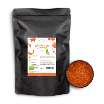Bio Hähnchengewürz neben offenem Behälter mit orange-roter, fein gemahlener Gewürzmischung.