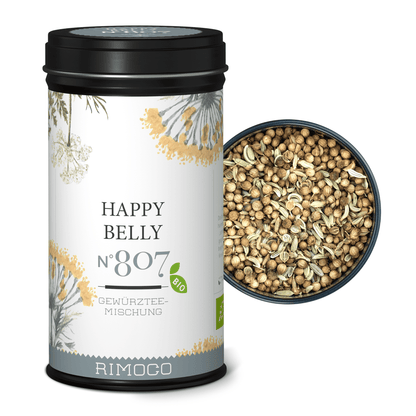 Dose mit Aufschrift Bio Ayurveda Tee Happy Belly, offener Deckel zeigt grobe Teemischung.