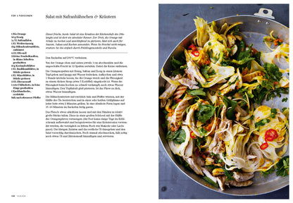 Große Salatpfanne mit Safranhähnchen, frischen Kräutern, Blattgrün und Zitronen; Geschenkset sichtbar.