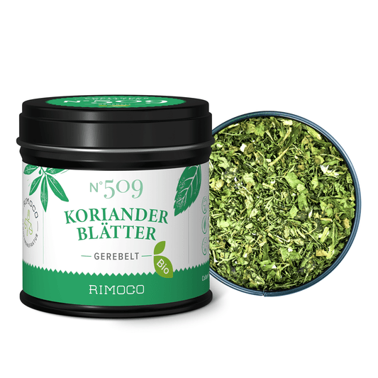 Eine geöffnete Dose mit Bio Korianderblättern zeigt grüne, getrocknete Korianderblätter.