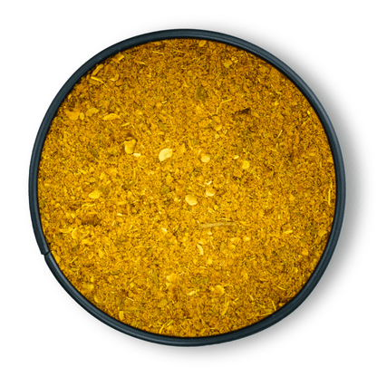 Runde schwarze Schale mit Bio Lemon Curry, von oben auf weißem Hintergrund gesehen.