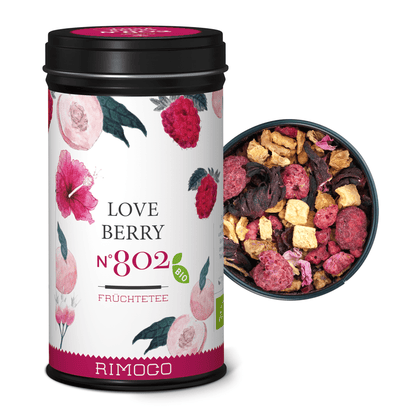 Bio Früchtetee Love Berry Dose neben einer Schale mit Rosen- und Hibiskusblüten.