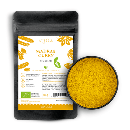 Bio Madras Curry neben einer Schale mit gemahlenem Currypulver.