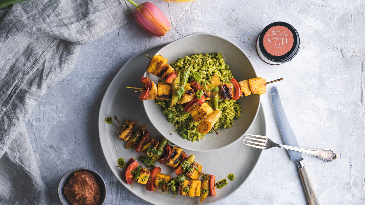 Gegrillte Gemüsespieße mit grünem Reis, dazu BBQ Rub sowie eine teilweise sichtbare Geschenkbox.