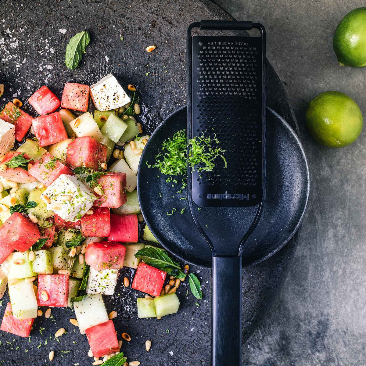 Wassermelonen-Gurken-Salat mit Limettenschale, daneben eine Microplane Zesterreibe Black Sheep.
