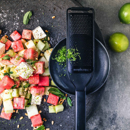 Wassermelonen-Gurken-Salat mit Limettenschale, daneben eine Microplane Zesterreibe Black Sheep.