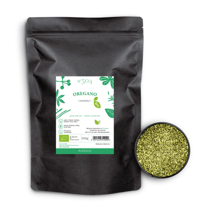 Bio Oregano gerebelt in schwarzer Tüte mit grün-weißem Etikett neben einer Schale getrockneter Oregano-Blätter.