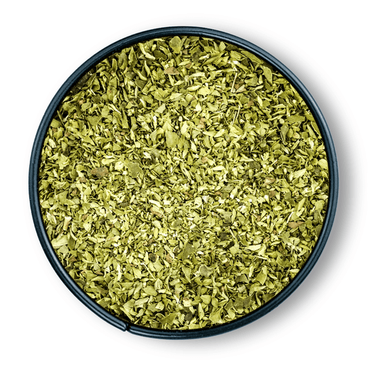 Schwarze Schale mit getrocknetem, gerebeltem Bio-Oregano von oben auf weißem Hintergrund.