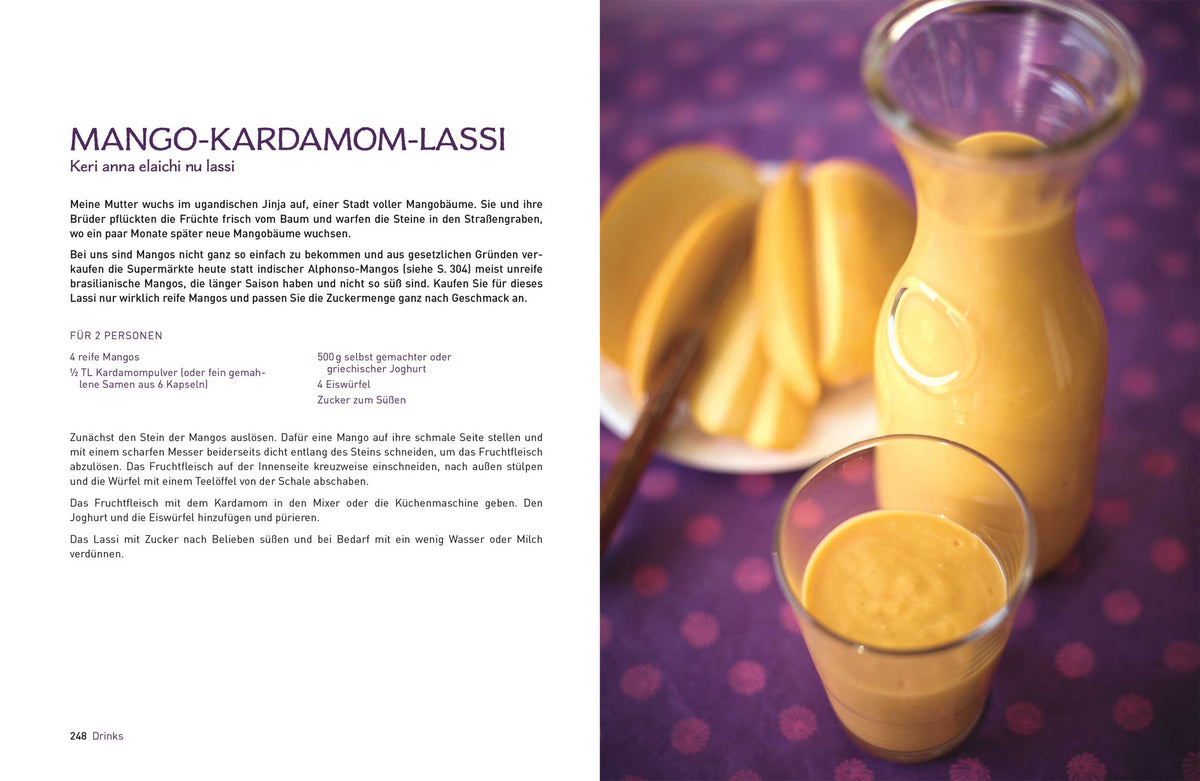 Ein Glas und ein Karaffe Original Indisch Mango Lassi mit frischer Mango auf einem Tisch.