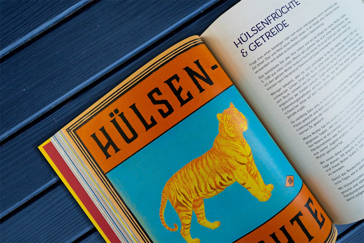 Geöffnetes Buch Original Indisch mit Tiger auf blauem Untergrund, deutscher Text zu Currys und Hülsenfrüchten.