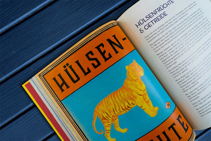 Geöffnetes Buch Original Indisch mit Tiger auf blauem Untergrund, deutscher Text zu Currys und Hülsenfrüchten.
