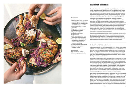 Zwei Hände reißen gegrilltes Hähnchen und Brot, dazu Rotkohlsalat und Zitronen.