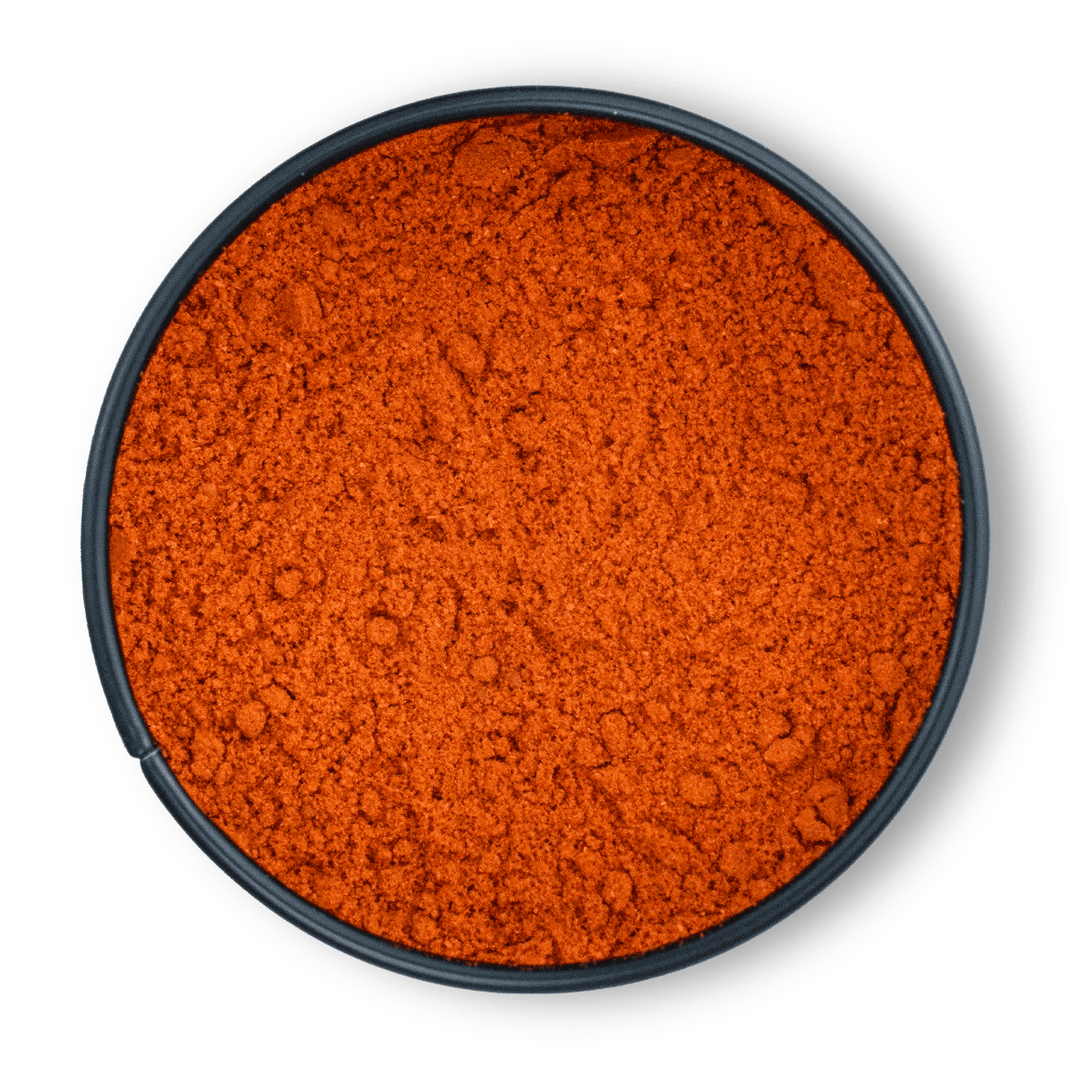 Runde schwarze Schale mit leuchtend rotem, gemahlenem Bio Paprikapulver, von oben gesehen.